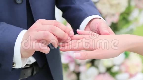 新郎戴着戒指戴在新娘的手指上视频的预览图