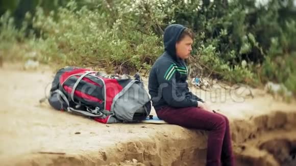 沙滩上背着旅游背包的小男孩视频的预览图