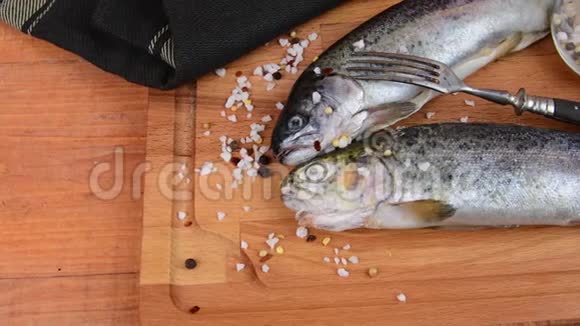 新鲜的生虹鳟鱼与香料和叉子在木板上健康食品和节食理念特写视频的预览图