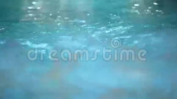 有瀑布和水下灯光的年轻夫妇在游泳池游泳视频的预览图