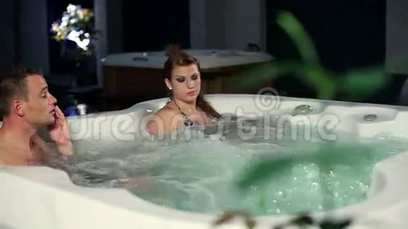年轻夫妇在温泉按摩浴缸里享受和放松视频的预览图