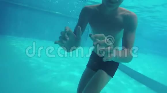孩子在水下少年在游泳池的水下游泳快乐的童年水下休息洗澡视频的预览图
