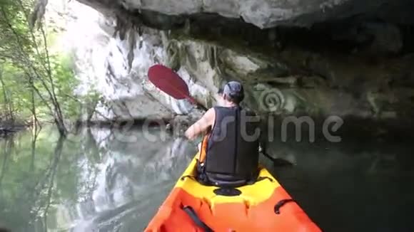 人类在悬崖洞穴里划船视频的预览图