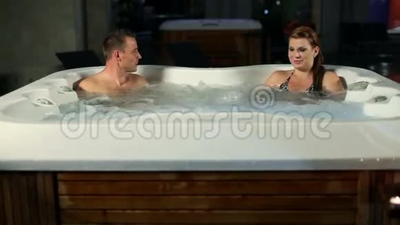 年轻夫妇在按摩浴缸里聊天晚上在浪漫的按摩浴缸里过夜视频的预览图