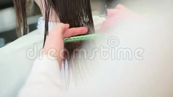理发师把女孩的头发剪得很近视频的预览图