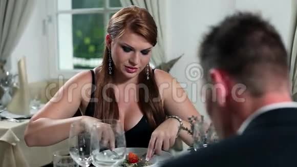 年轻夫妇在芬奇餐厅吃浪漫晚餐他们正在吃东西视频的预览图