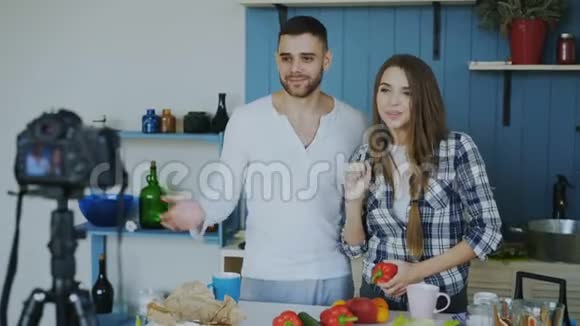 在家中的厨房里在dslr摄像机上录制关于素食健康食品的视频博客这对夫妇很有魅力视频的预览图