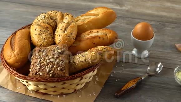 牛奶黄油饼干鸡蛋和新鲜面包放在乡村木桌上乡村早餐视频的预览图