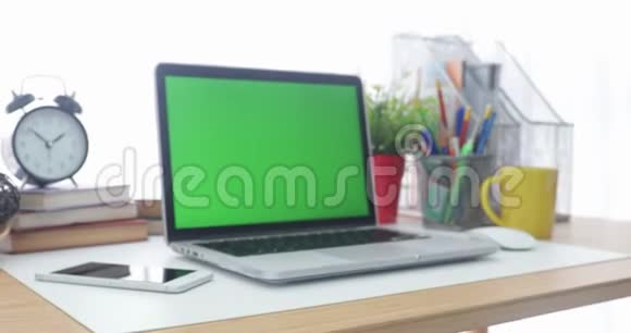 4K一台笔记本电脑在工作办公室桌子上设置一个绿色的关键屏幕多利在视频的预览图