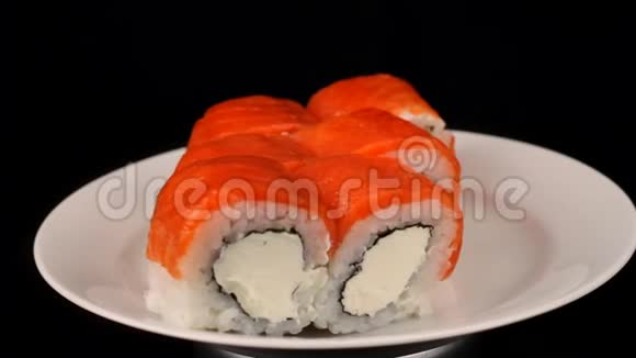费城餐卷在盘子上旋转日本菜在黑色背景上旋转视频的预览图