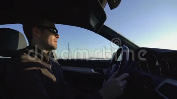成功男企业家戴墨镜的肖像开车时在镜头前讲话视频的预览图
