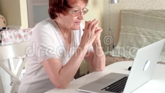 老妇人用笔记本电脑通过Skype与孙女交谈视频的预览图