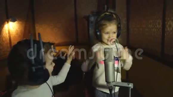 两个戴着耳机的小女孩拿着麦克风唱歌视频的预览图