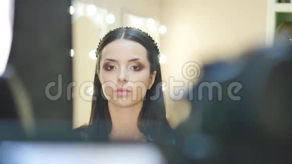 用化妆刷涂上眼区的美丽年轻黑发女人的特写肖像视频的预览图