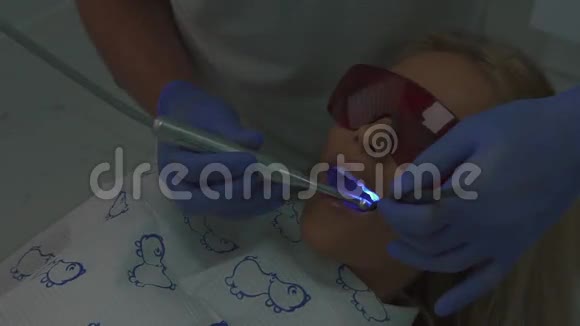 牙科医生的病人口腔医生助理使用初级蓝光硬化牙科复合材料视频的预览图