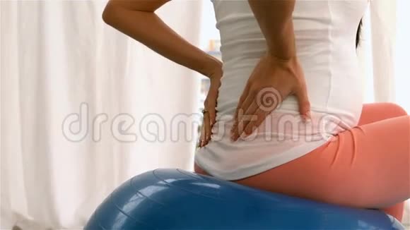 坐在健身球上的孕妇背部视频的预览图