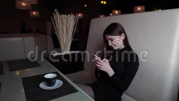 咖啡馆里的女孩用你的电话在社交网络上交流视频的预览图