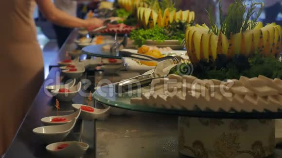 酒店餐厅的自助餐人们去餐桌上拿食物奶酪视频的预览图