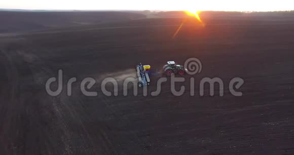 日落时种植小麦的拖拉机的俯视图视频的预览图