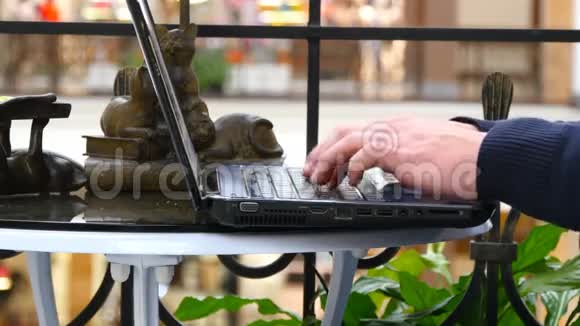 男性手在购物中心的笔记本电脑键盘上打字视频的预览图