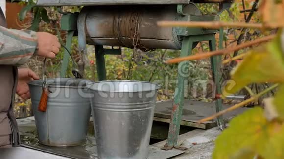 人们把链子和水桶一起扔进乡间的井里取水脏水视频的预览图
