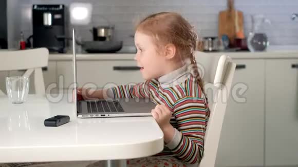 小女孩用笔记本电脑通过Skype和妈妈聊天视频的预览图