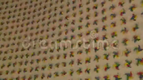 彩虹旋转的风车旋转在白色的墙壁上视频的预览图