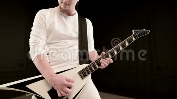 时尚的独奏吉他手头上戴着可怕的石头黑色背景上穿着白色衣服富有表现力地演奏着视频的预览图