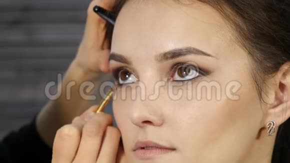 专业化妆师在客户脸上做眼妆美容时尚产业视频的预览图