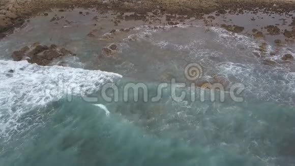 海浪和岩石海岸的鸟瞰图视频的预览图
