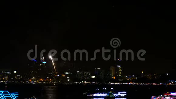 4K镜头真实的烟花节在天空中以庆祝夜晚城市的景色在背景和船漂浮在海上视频的预览图