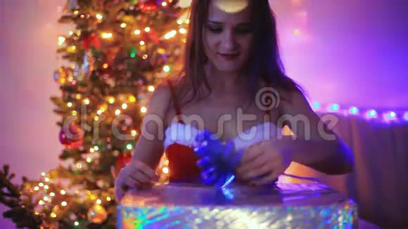 年轻快乐的女人用魔法灯打开神奇的圣诞礼物打开盒子后女孩们头发飞扬女孩视频的预览图
