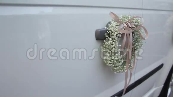 门把手上装饰着结婚花的婚礼车视频的预览图