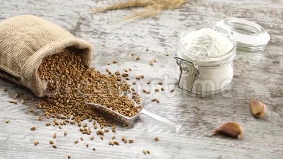 一小袋小麦面粉大蒜和新鲜的面包在一个乡村的木制桌子上视频的预览图