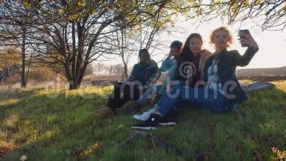 四个多种族的朋友坐在农村视频的预览图