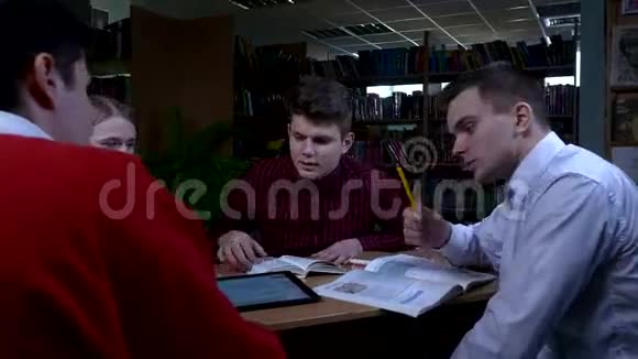 一群学生坐在图书馆的桌子旁视频的预览图