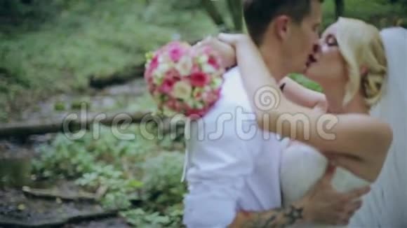 一对漂亮的新婚夫妇在森林里接吻视频的预览图