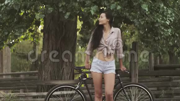 站在户外自行车的年轻女子视频的预览图