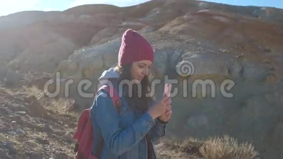女徒步旅行者在山顶用手机拍照视频的预览图