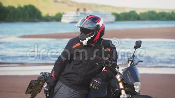 摩托车手躺在摩托车旁边的河岸上视频的预览图