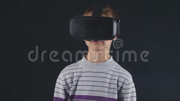 男孩获得使用VR头套的经验增强现实设备为智能手机应用程序创建虚拟空间视频的预览图