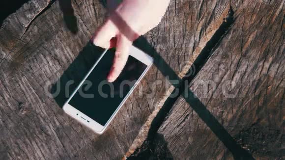 手指手势女孩在木制背景下管理智能手机视频的预览图