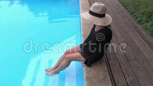 戴草帽的女人在游泳池边上放松视频的预览图