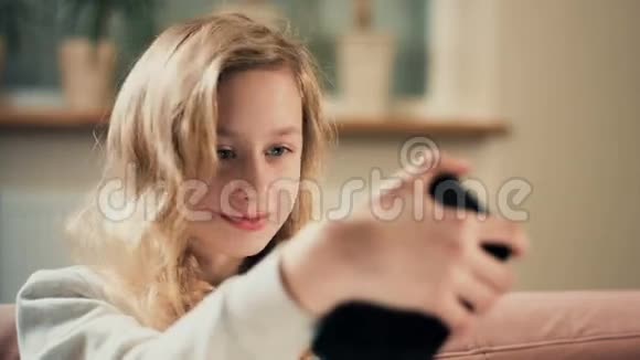 一位美丽的金发女孩用手机拍自拍肖像视频的预览图