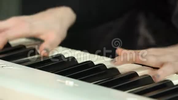 女子双手弹奏白色数字钢琴特写镜头配合离焦女孩用手指在键盘或视频的预览图