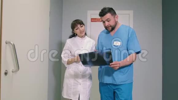 两位医生一男一女走在诊所的走廊里互相交谈与斯泰迪奇姆4k射击视频的预览图