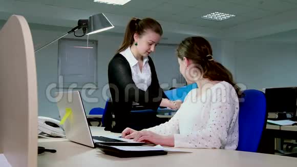 两个在办公室工作的女商人在电脑里视频的预览图