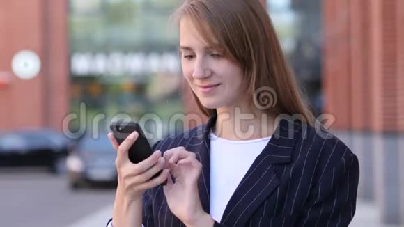 商界女性在使用智能手机时庆祝成功视频的预览图