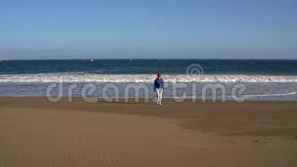 活跃的徒步旅行者女人从水中走在海滩上加那利群岛特内里夫带背包的白人年轻妇女视频的预览图