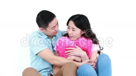 微笑的亚洲夫妇坐在一起拥抱枕头视频的预览图